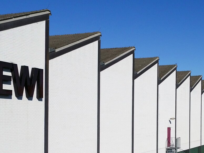 168一分钟极速赛车官网 factory with white façade, "HEWI" lettering and shed roof